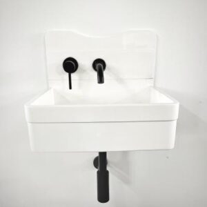 Vintage white ceramic bathroom sink with black taps and a wall mount, ideal for classic and contemporary bathroom designs. Perfect for renovation or new installations.